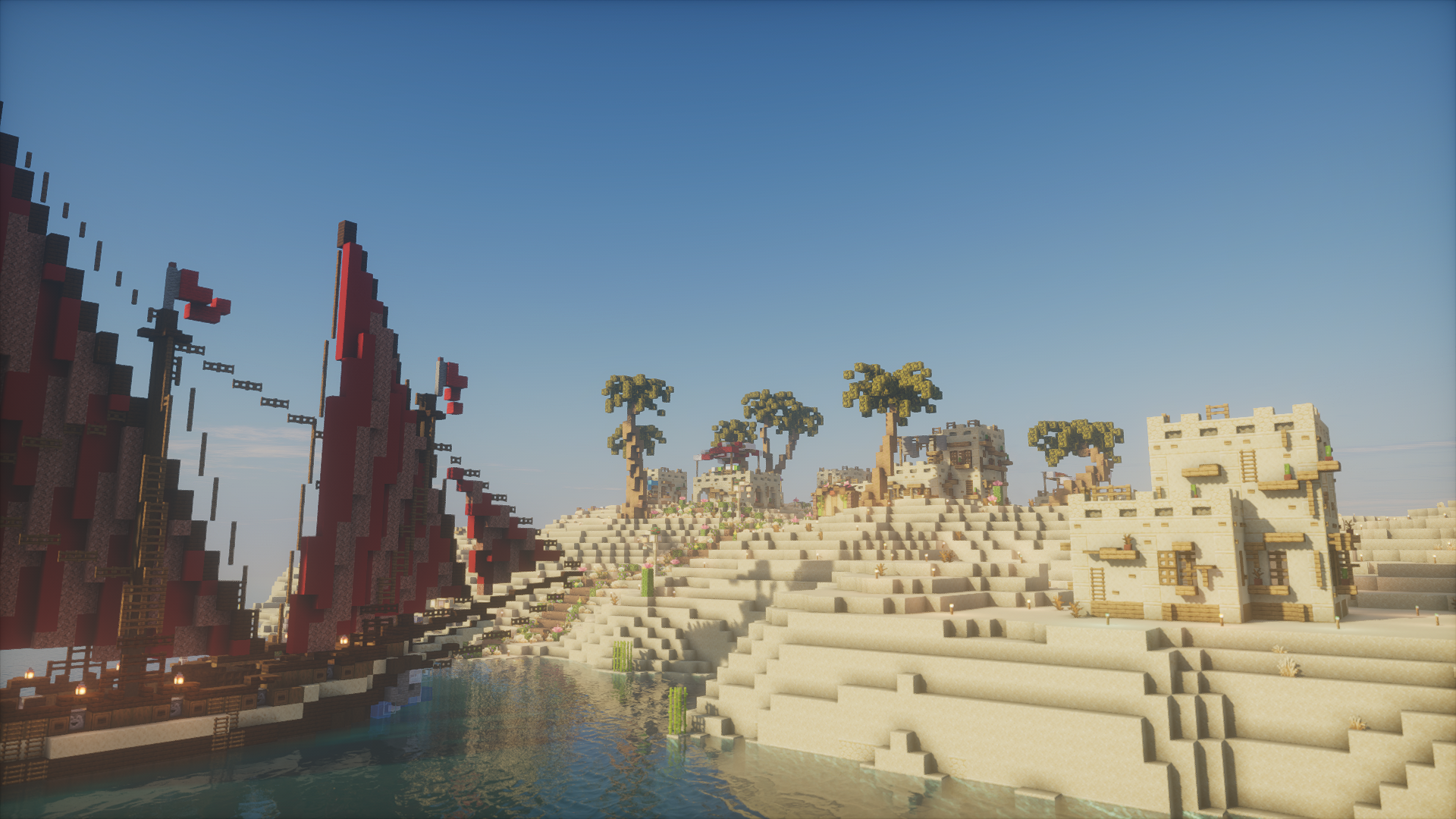 Red-sailed ships beside a sandstone desert settlement