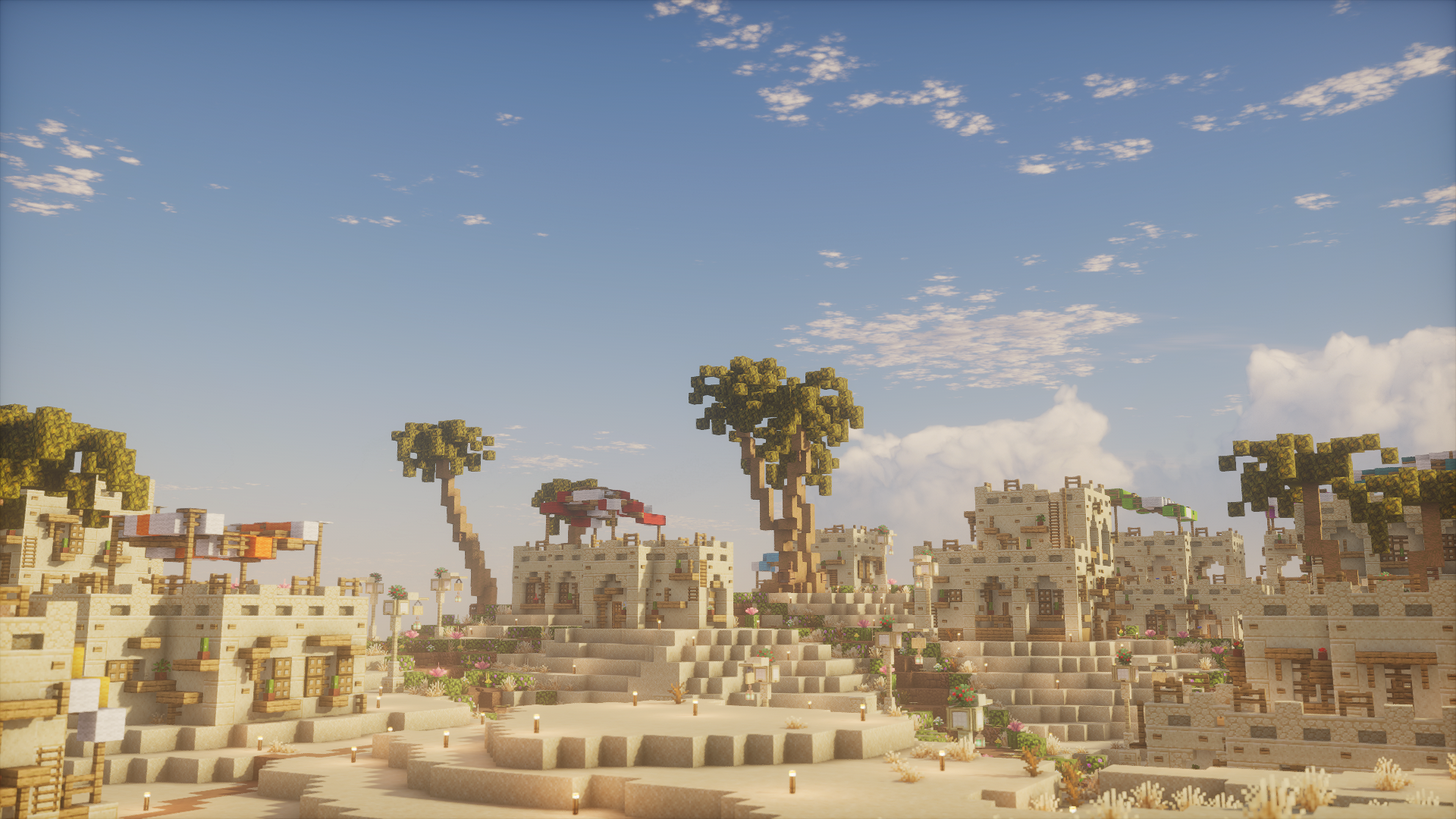 A terraced sandstone village with flowers and acacia trees
