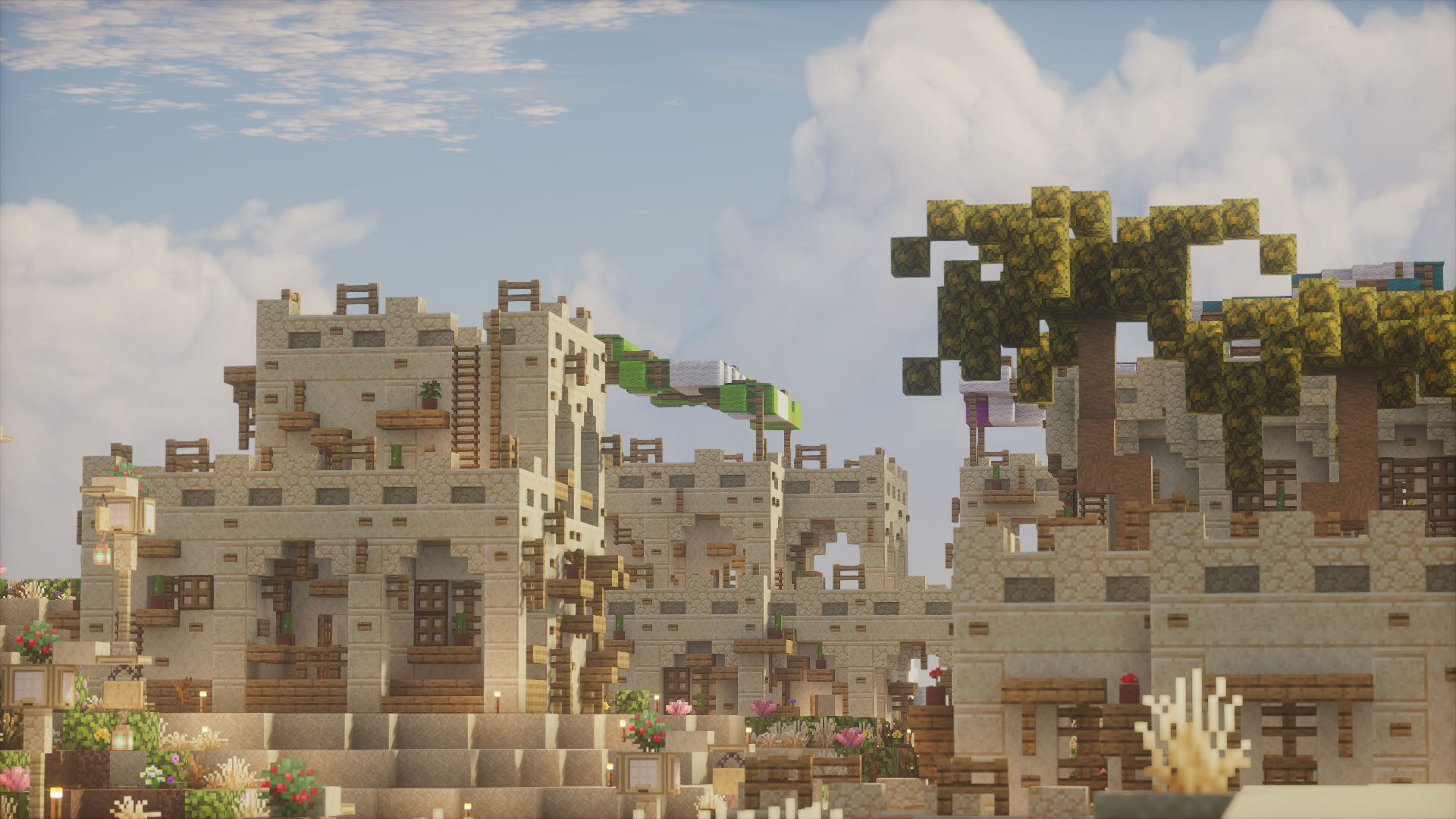 Layered sandstone rooftops beneath acacia trees and clouds